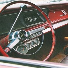 the interior of an old car with steering wheel and dashboard