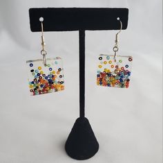 This delightful pair of earrings features a UV resin poured piece with inlaid rainbow colored beads designed to look as though they're raining down and collecting at the bottom of the piece.  Earrings come with backs attached. I buy quality materials but cannot personally attest that they are 100% allergen free for people with certain metal sensitivities. They are lightweight so as not to strain your earlobes or stretch your holes but still have a bold impact. Rainbow Round Earrings With Colorful Beads, Rainbow Crystal Drop Earrings For Gift, Rainbow Drop Earrings With Colorful Beads, Nickel-free Rainbow Drop Earrings, Vibrant Rainbow Dangle Earrings, Steampunk Earrings, Resin Pour, Rainbow Beads, Purple Crystals