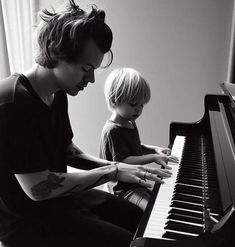 a man and child are playing the piano