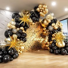 black and gold balloons are arranged in the shape of stars