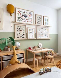 a child's room with green walls and pictures on the wall, including children's toys