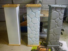 three tall white vases sitting next to each other in a garage with tools on the floor