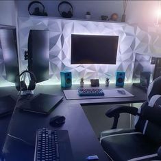 a computer desk with a keyboard, monitor and speakers in front of a wallpapered background