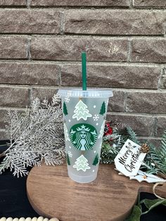 a starbucks cup sitting on top of a wooden table next to christmas decorations and greenery