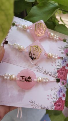 two pink and white hair clips on top of a piece of paper next to flowers