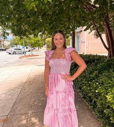 Smocked tiered ruffle midi dress + Striped fabric + Square neckline with ruffle trim + Smocked flutter sleeves + Ruffle waist trim with tying detail + Tiered ruffle trim + Pockets + Lined + Model is 5’10” 32-25-35 and wears a S Red Striped Dress, Ruffle Midi Dress, Striped Fabric, Stripe Dress, Red Stripe, Fabric Squares, Square Necklines, Flutter Sleeves, Ruffle Trim