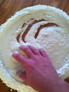 someone is kneading the dough into a pie crust on top of a wooden table