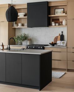 a modern kitchen with black cabinets and white counter tops, an island in the middle