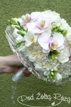 a bouquet of white and pink flowers in someone's hand