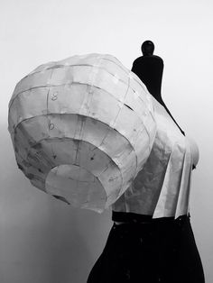 a black and white photo of a mannequin's torso with paper covering it