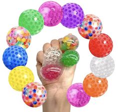 a hand holding a bunch of colorful balls