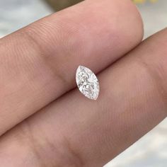 a close up of a person's hand holding a diamond