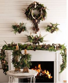 a fireplace decorated for christmas with greenery and deer heads on it's mantle