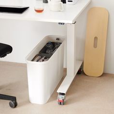 a white desk with a trash can underneath it