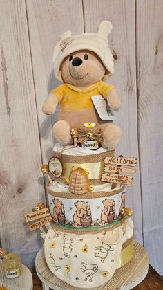 a large teddy bear sitting on top of a stack of diapers with other items around it