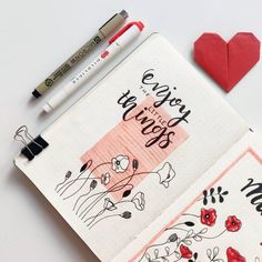 an open notebook with writing on it next to a red heart and two markers that say we love you