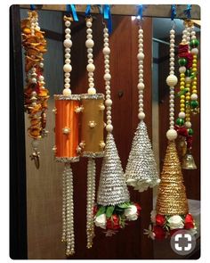 several different types of bells hanging from the ceiling in front of a mirror with blue ribbon