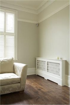 a white couch sitting next to a window on top of a hard wood floor in a living room