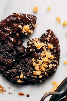 a chocolate cookie with crumbs on it next to a pair of scissors