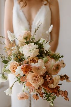 a bride holding a bouquet of flowers in her hands