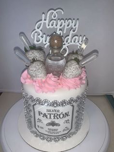 a birthday cake that is decorated with silver and pink frosting, baseball bats and bottles