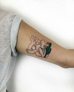 a person with a tattoo on their arm holding a green cactus in the other hand