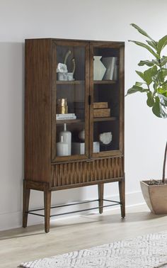 a wooden cabinet sitting next to a potted plant