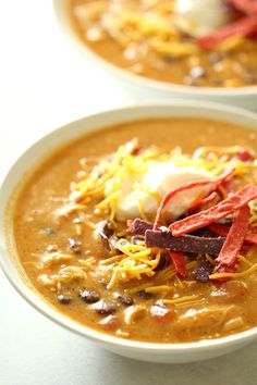 two bowls filled with soup on top of a table