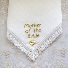 Unique new and unused hand embroidered 'mother of the bride' cotton lawn handkerchief edged with authentic Nottingham lace circa 1950. I have used charcoal grey 100% colour fast embroidery thread for the inscription on this gorgeous handkerchief. This lovely keepsake is finished of with a mother of pearl pink heart shaped button. The handkerchief measures 28 cms x 28 cms. I have other vintage hankies in similar designs and I would be more than happy to make one up to your personal colour scheme. Traditional Wedding Handkerchiefs With Embroidered Border, Embroidered Lace Handkerchiefs For Wedding, Cotton Handkerchiefs With Lace Trim For Wedding, Mother's Day White Cotton Handkerchiefs, White Cotton Handkerchiefs For Mother's Day, Jade Wedding, Nottingham Lace