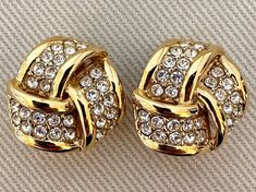 "Timeless Infinity Love Knot Clip On Statement Earrings with Crystal Accents c. 1980s  -Shiny gold tone finish, clear crystal accents  -Unsigned  -Excellent vintage condition  -Clip ons  -Size: 1\" diameter" Luxury Classic Round Clip-on Earrings, Luxury Timeless Yellow Gold Clip-on Earrings, Luxury Gold-tone Clip-on Earrings, Diamond Earrings Design, Infinity Love, Earrings Design, Love Knot, Designer Earrings, Clear Crystal