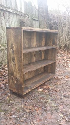 an old wooden bookcase sitting in the woods