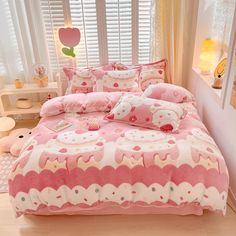 a bed with pink and white comforters in a child's bedroom, next to a window