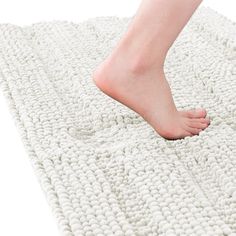 a person's bare foot is on a white rug that looks like a knitted blanket