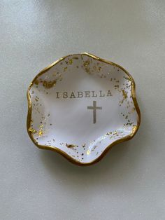 a white and gold plate with a cross on it that says i sabellaa