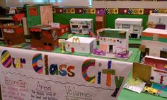 a display table with cardboard houses and mcdonald's logos on it for class city