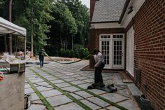 two men are working on an outdoor patio