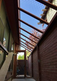 an open walkway leading to a building with a skylight above it and trees in the background