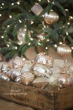 a wooden box filled with ornaments next to a christmas tree