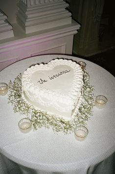 a heart shaped cake on a table with candles