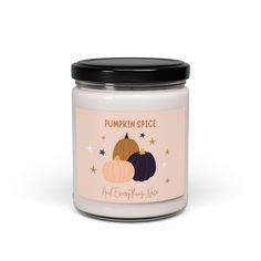 pumpkin spice soy candle in a glass jar with black lid and stars on the side