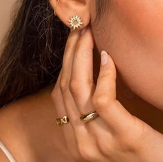 a close up of a person wearing two different rings and one with a flower on it