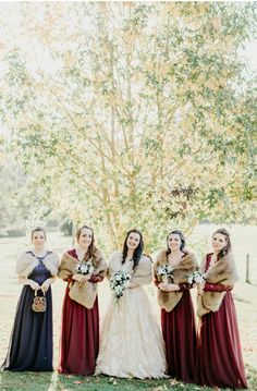 the bridesmaids are dressed in long dresses and fur stoles for their winter wedding