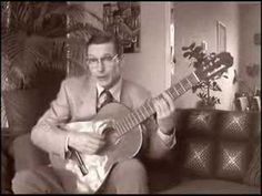 a man sitting on a couch playing a guitar