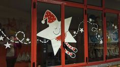 a storefront with christmas decorations on the window and in front of it is a decorated star