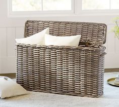 a wicker basket with two white pillows