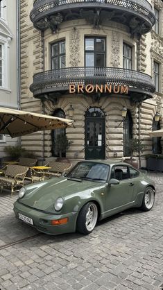 a green sports car parked in front of a restaurant