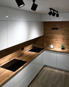 a kitchen with white cabinets and wooden counter tops in arabic calligraphy on the wall