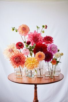 there are many vases with flowers in them on the table