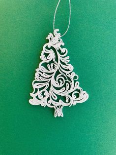 a white christmas tree ornament on a green background