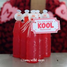 three red soda bottles with valentine's day tags on them